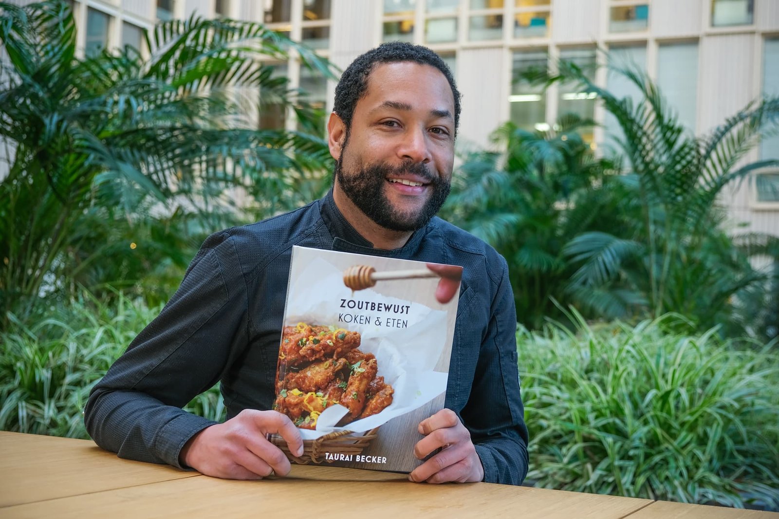 Foto van Taurai Becker met zijn kookboek zoutbewust koken en eten